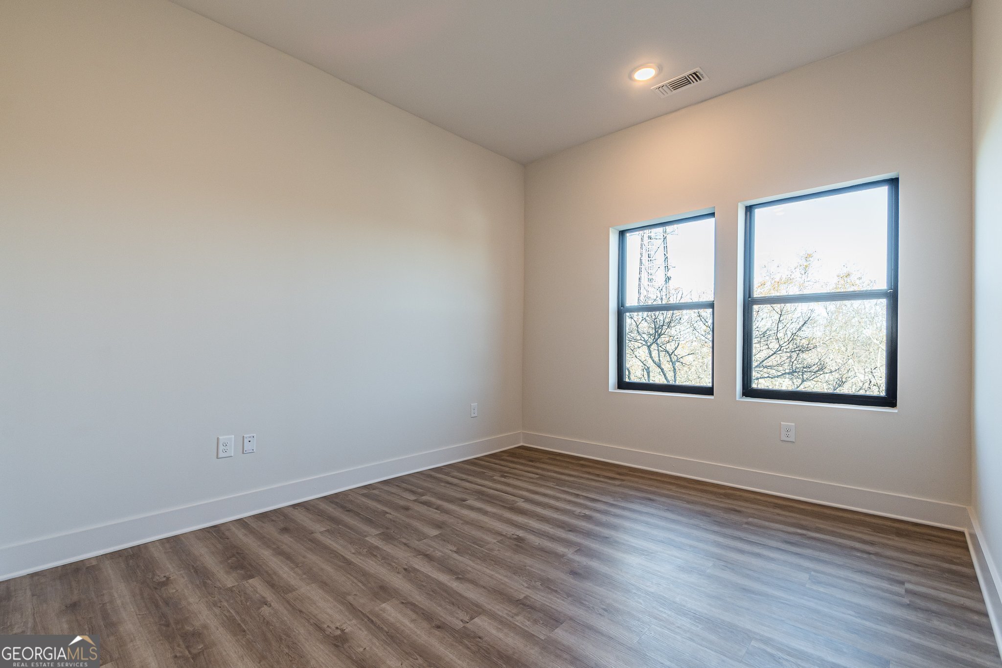 112 Rogers Street Northeast, Unit 601 Atlanta, GA 30317 - Photo 14 of 31 an empty room with wooden floor and windows
