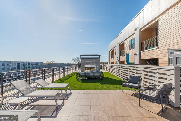 a view of a patio with a table and chairs with wooden floor and fence