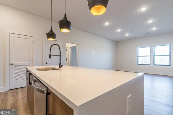 a kitchen with a sink a counter space and wooden floor