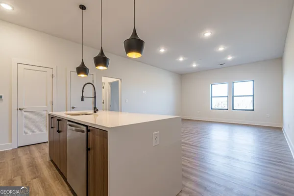 a kitchen with kitchen island a sink stainless steel appliances and wooden floor