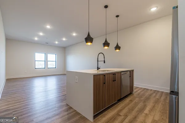 a kitchen with a sink and wooden floor