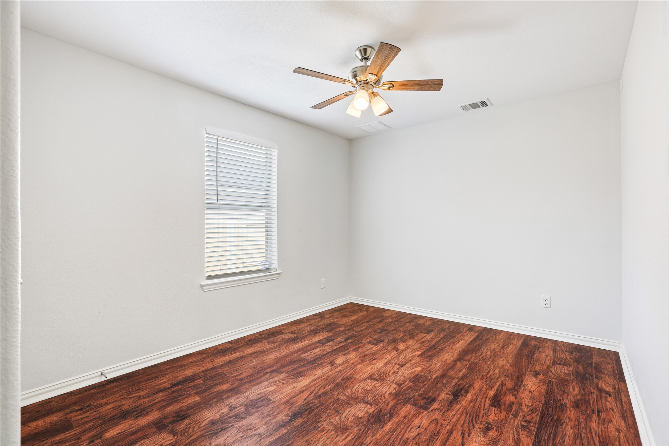 3900 Brean Down Road Pflugerville, TX 78660 - Photo 17 of 35 an empty room with wooden floor fan and windows