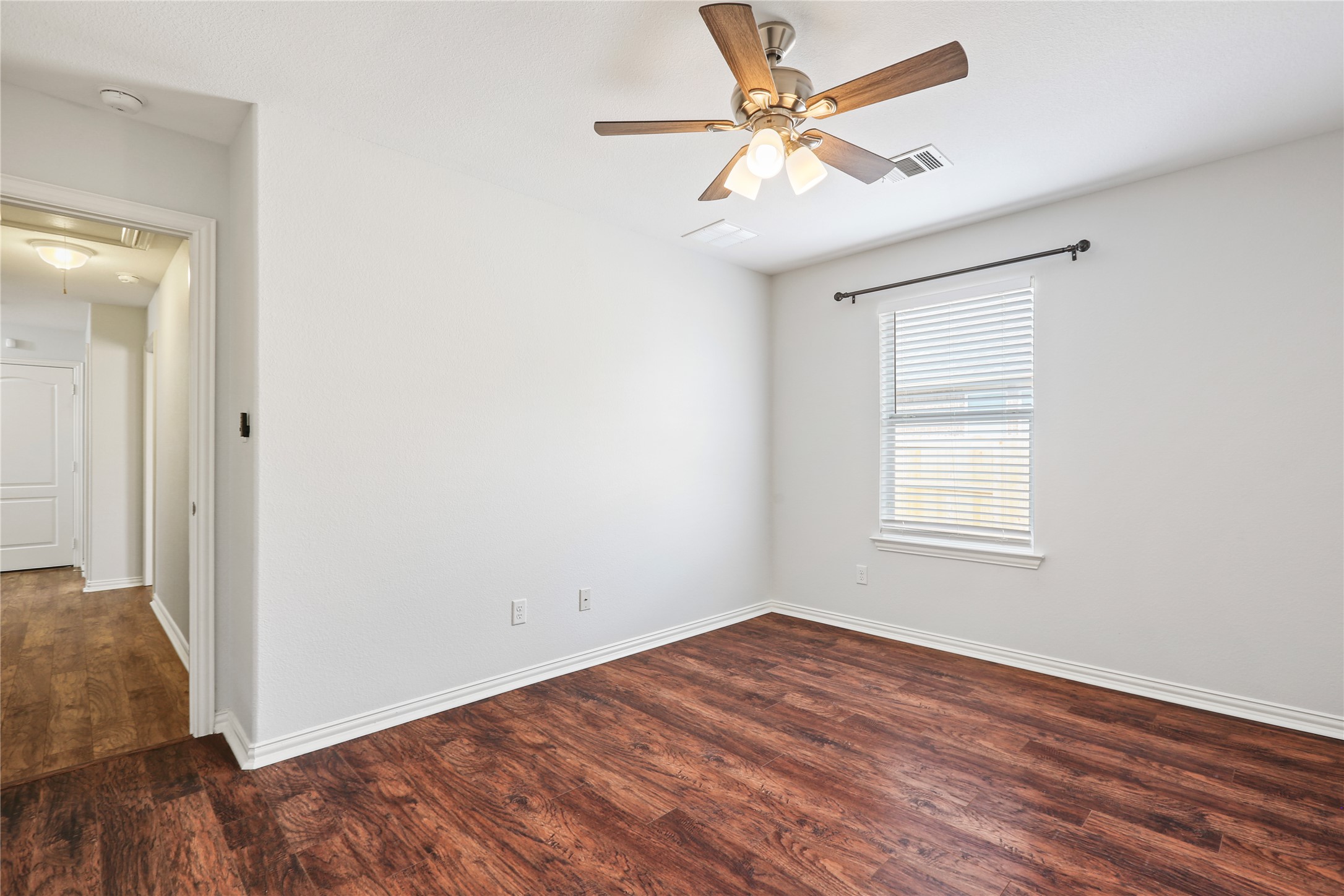 3900 Brean Down Road Pflugerville, TX 78660 - Photo 19 of 35 an empty room with wooden floor fan and windows