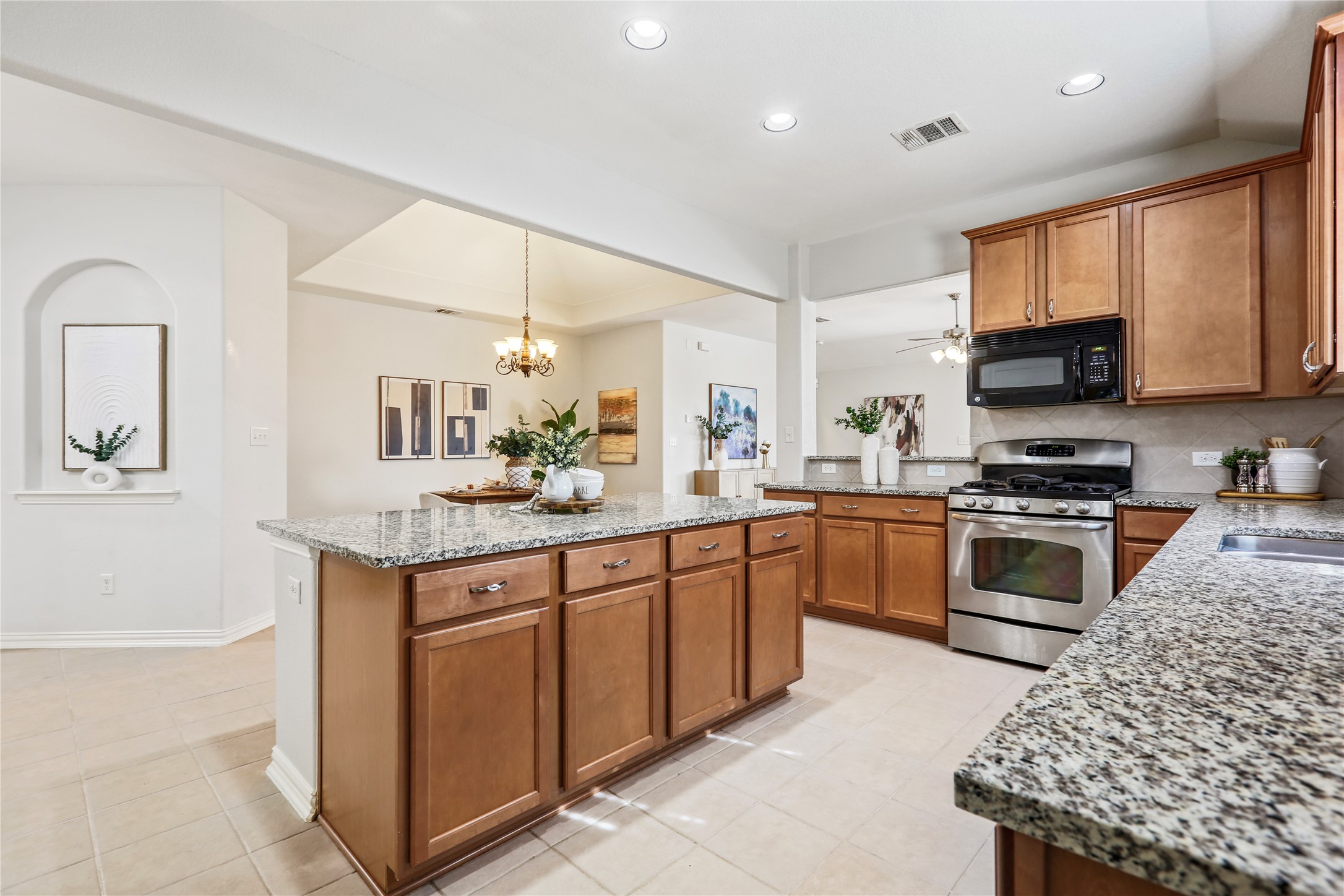 3900 Brean Down Road Pflugerville, TX 78660 - Photo 5 of 35 a kitchen with stainless steel appliances granite countertop a stove top oven a sink dishwasher and a refrigerator with wooden floor