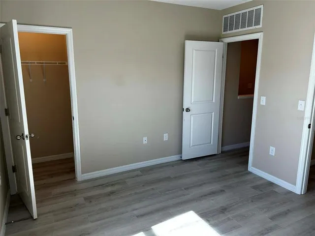 an empty room with wooden floor and closet