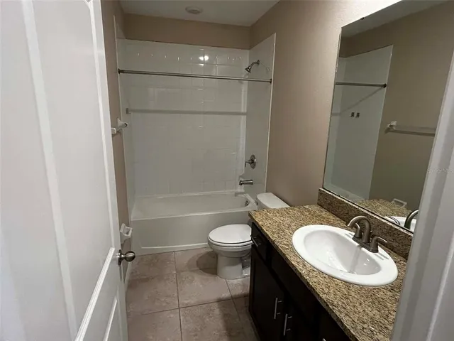a bathroom with a granite countertop sink toilet mirror and shower