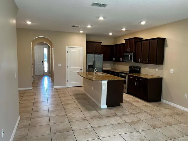 a kitchen with stainless steel appliances granite countertop a refrigerator and a stove