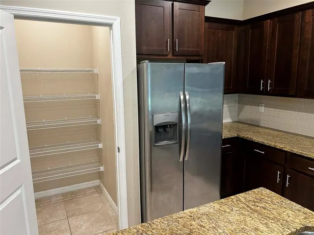 a kitchen with a refrigerator and wooden cabinets