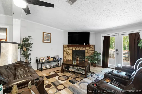 a living room with furniture a flat screen tv and a fireplace
