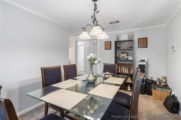 a view of a dining room with furniture and chandelier