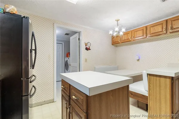 a kitchen that has a fridge and a table in it