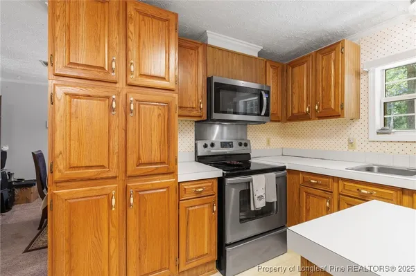 a kitchen with stainless steel appliances granite countertop a stove top oven a sink dishwasher and microwave with wooden floor