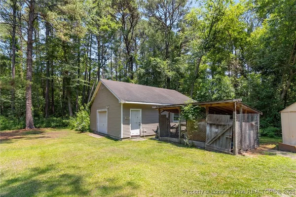 a view of a house with a yard and large tree