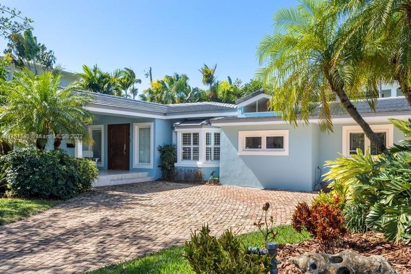 710 Woodcrest Road Key Biscayne, FL 33149 - Photo 1 of 34 a front view of a house with a yard and potted plants