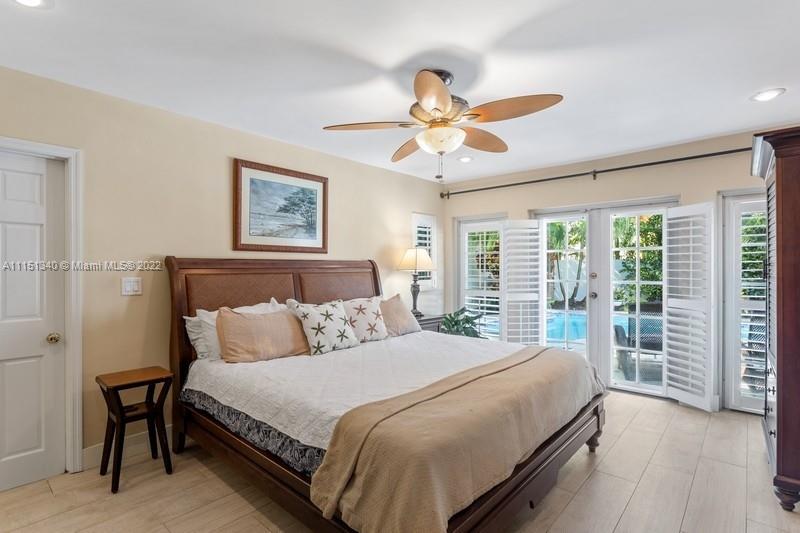 710 Woodcrest Road Key Biscayne, FL 33149 - Photo 13 of 34 a bedroom with a large bed and a chandelier
