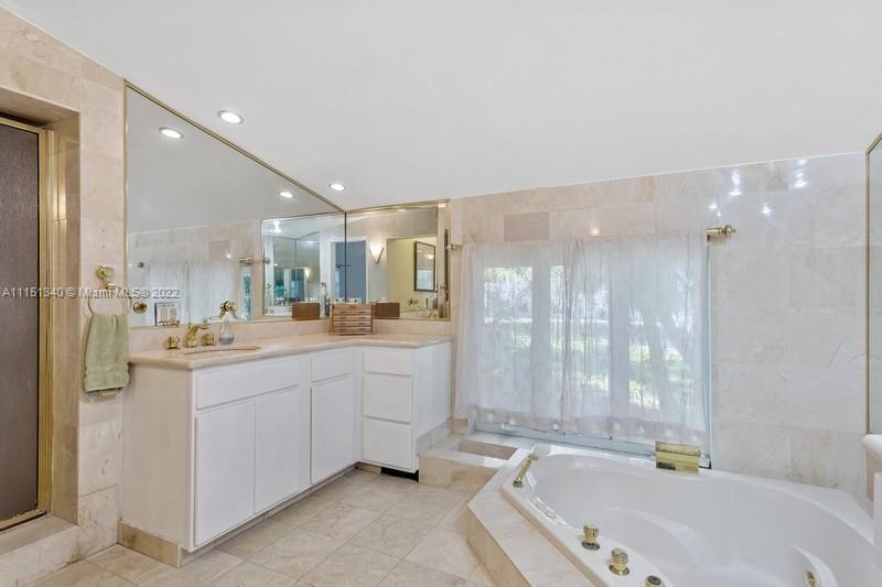 710 Woodcrest Road Key Biscayne, FL 33149 - Photo 15 of 34 a bathroom with a granite countertop sink mirror bathtub and shower