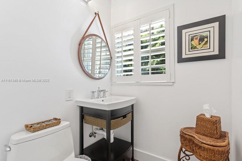 710 Woodcrest Road Key Biscayne, FL 33149 - Photo 17 of 34 a bathroom with a toilet a sink and a mirror