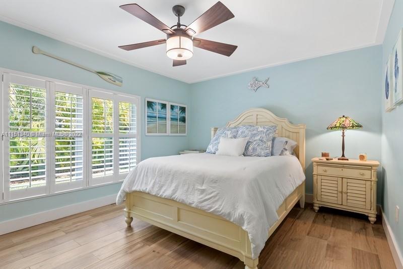710 Woodcrest Road Key Biscayne, FL 33149 - Photo 18 of 34 a bedroom with a bed chandelier and window
