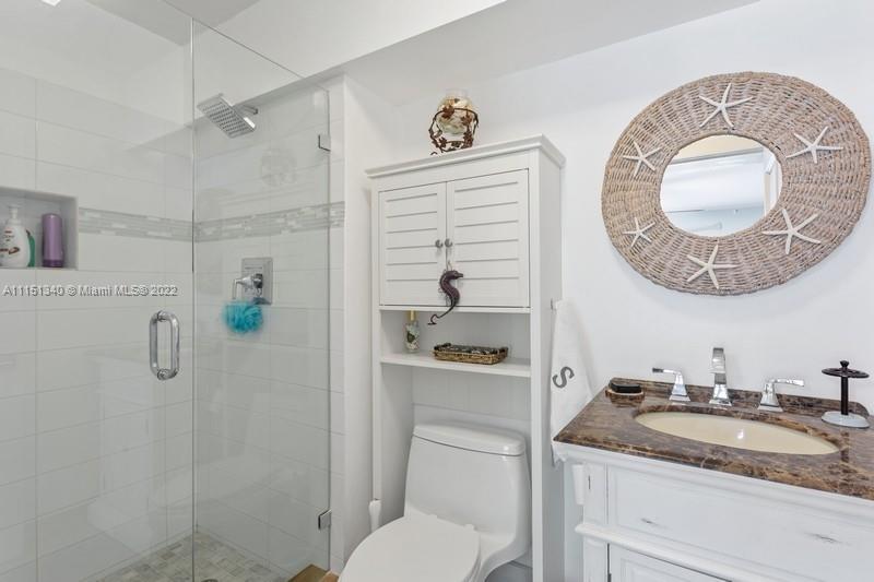 710 Woodcrest Road Key Biscayne, FL 33149 - Photo 19 of 34 a bathroom with a granite countertop sink a toilet and shower