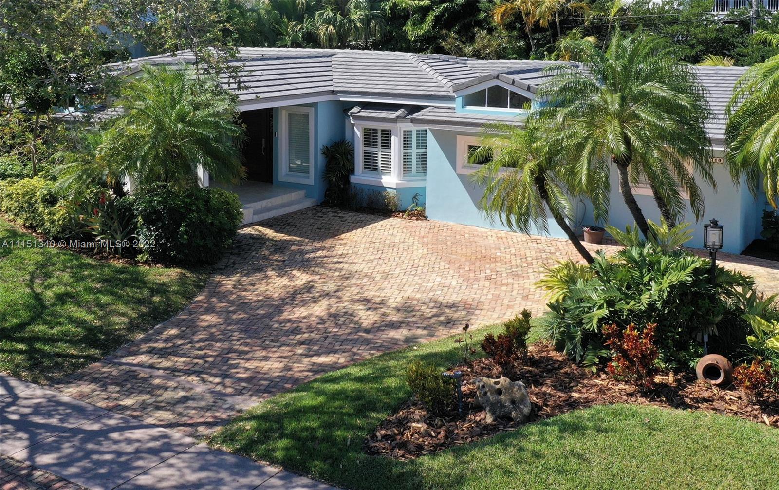 710 Woodcrest Road Key Biscayne, FL 33149 - Photo 3 of 34 a front view of a house with a yard and garage