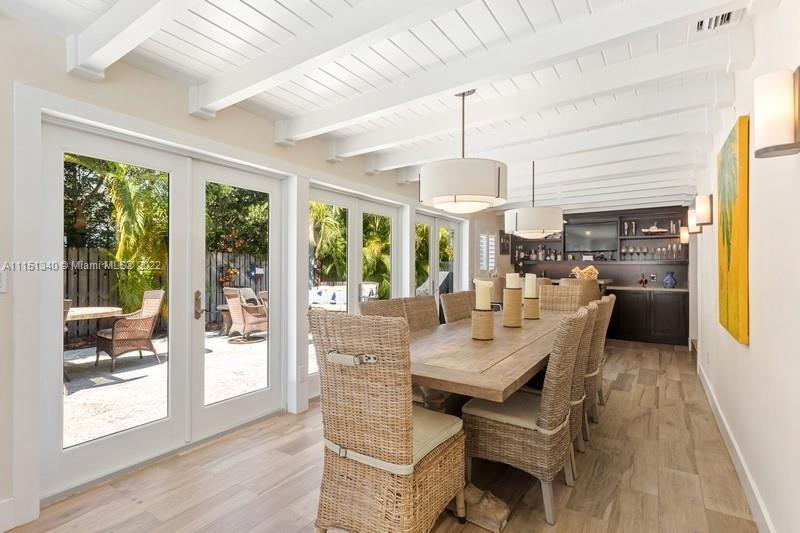 710 Woodcrest Road Key Biscayne, FL 33149 - Photo 10 of 34 a view of a dining room with furniture large windows and wooden floor