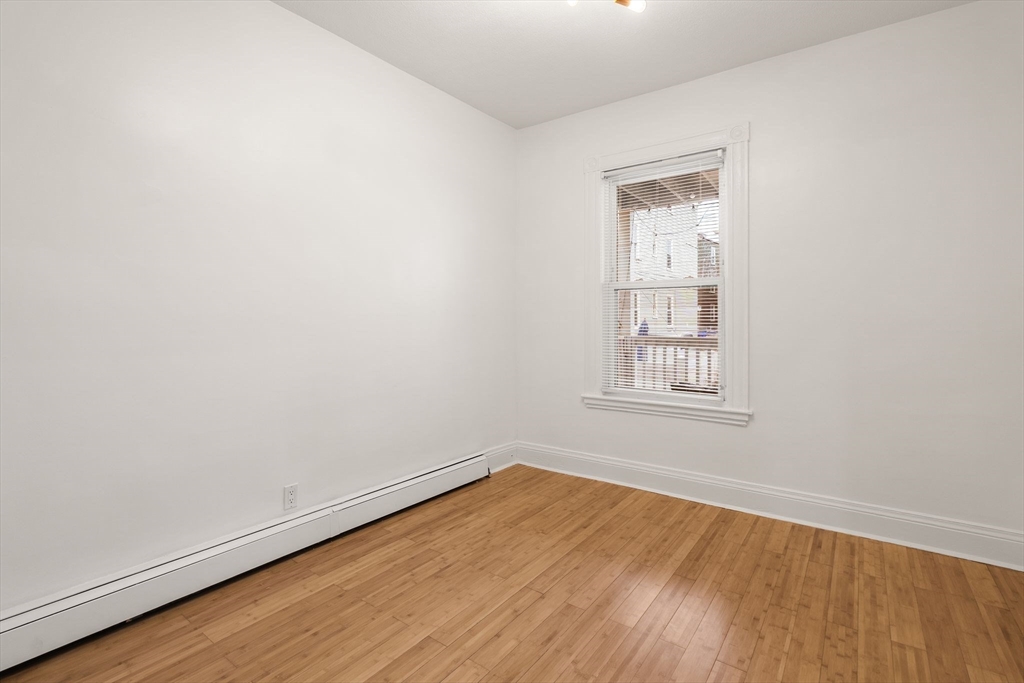 3 Spring Garden Street, Unit 1 Boston, MA 02125 - Photo 13 of 23 an empty room with wooden floor and windows
