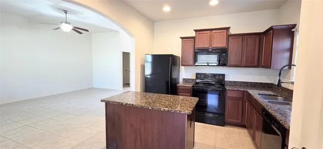 a kitchen with stainless steel appliances granite countertop a refrigerator stove and oven