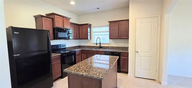 a kitchen with stainless steel appliances granite countertop a refrigerator and a stove