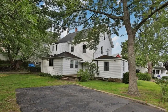 a white house that has a tree in front of the house