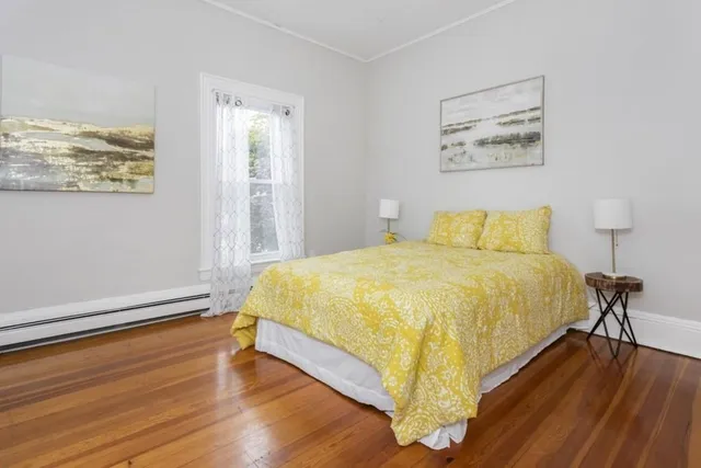 a bed sitting in a bedroom next to a window