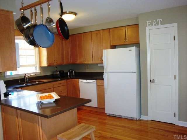 5912 Rondan Circle Raleigh, NC 27612 - Photo 5 of 12 a kitchen with stainless steel appliances granite countertop a refrigerator a sink dishwasher a stove and a dining table with wooden floor