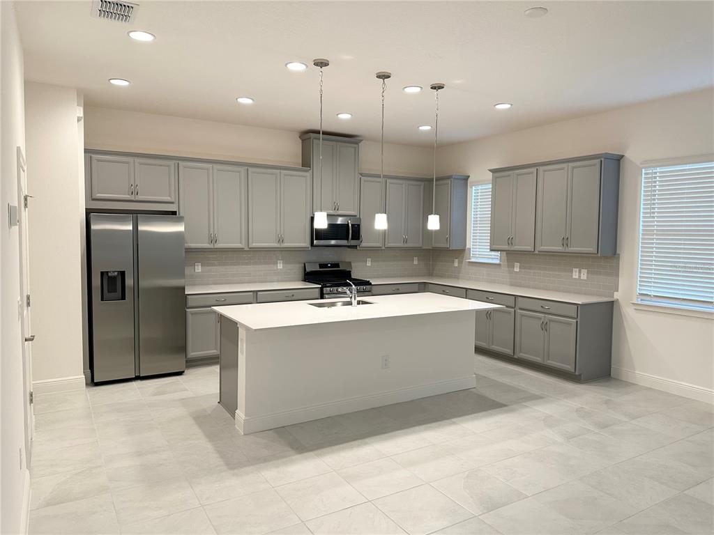 5282 Buttonsage Drive St. Cloud, FL 34772 - Photo 2 of 43 a large kitchen with stainless steel appliances lots of counter top space cabinets and a sink