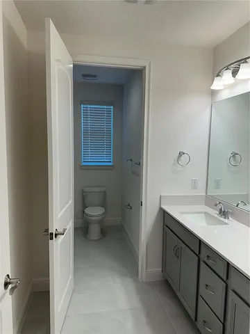 a spacious bathroom with a toilet sink and mirror