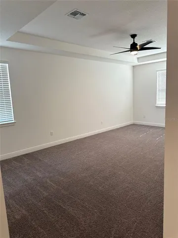 an empty room with a ceiling fan and window