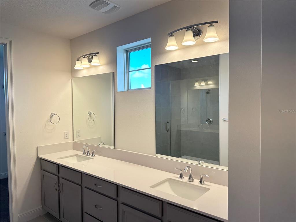 5282 Buttonsage Drive St. Cloud, FL 34772 - Photo 35 of 43 a bathroom with a double vanity sink and a mirror