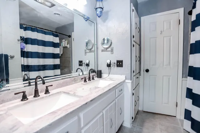 a bathroom with a sink a toilet and a large mirror