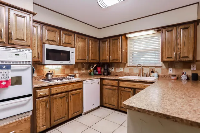 a kitchen with stainless steel appliances granite countertop a refrigerator stove top oven and sink