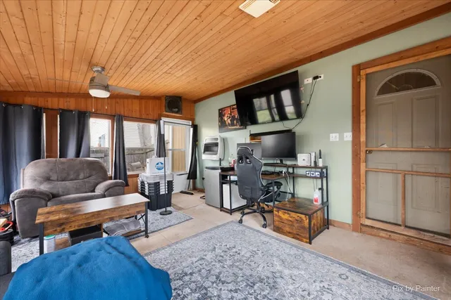 a living room with furniture a flat screen tv and floor to ceiling window