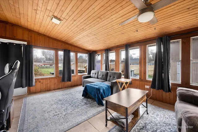 a living room with furniture a flat screen tv and a floor to ceiling window