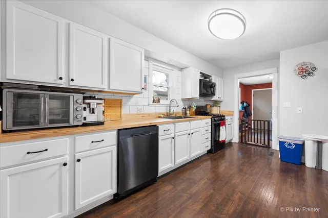 a kitchen with granite countertop white cabinets and white appliances