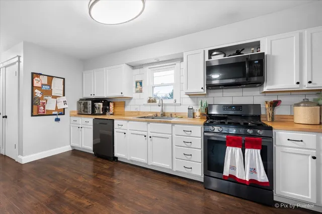 a kitchen with stainless steel appliances a stove microwave and sink