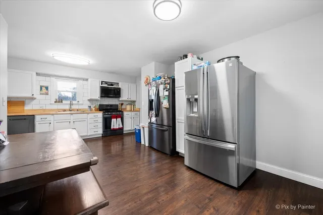 a kitchen with stainless steel appliances a refrigerator and wooden floor