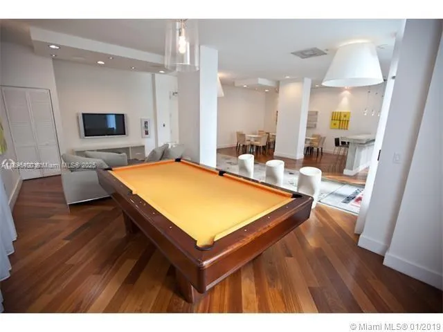 a room with pool table and windows