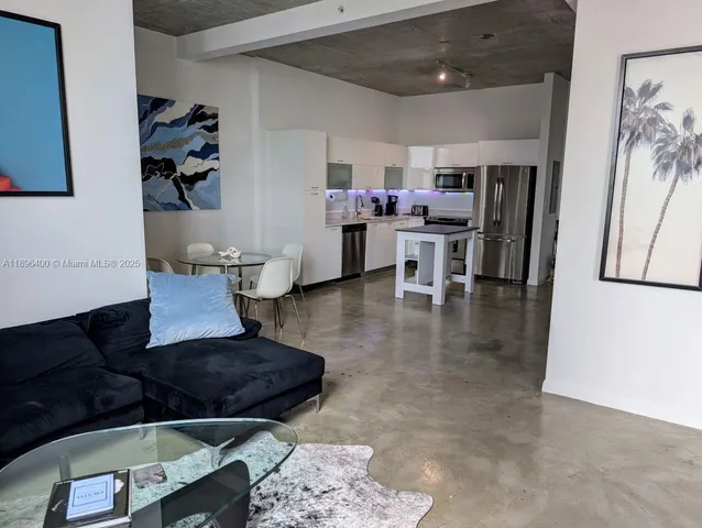 a living room with furniture and view of kitchen