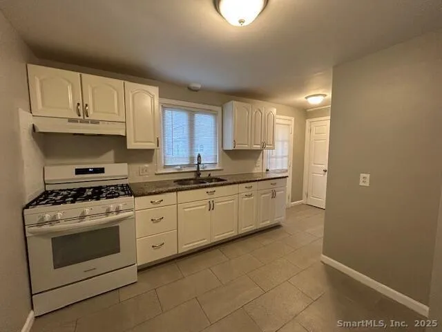 a kitchen with a stove top oven sink and cabinets