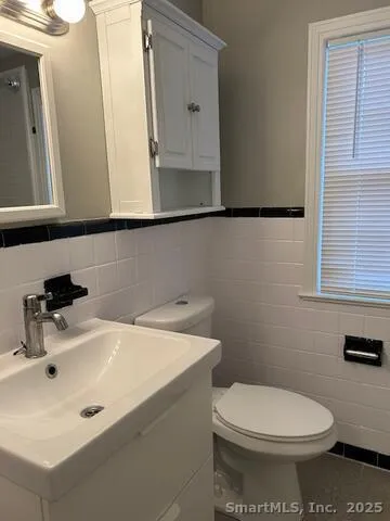 a bathroom with a sink a toilet and mirror