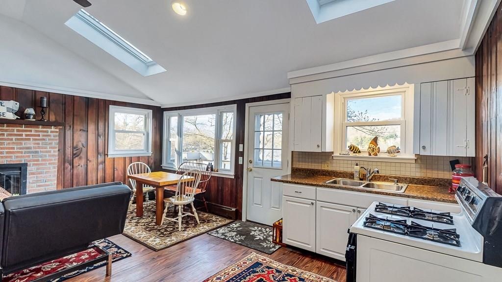 28 Stony Hill Road Holland, MA 01521 - Photo 14 of 27 a kitchen with stainless steel appliances granite countertop a stove a sink dishwasher a dining table and chair with wooden floor