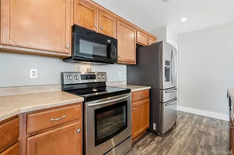 a kitchen with stainless steel appliances granite countertop a stove microwave and refrigerator