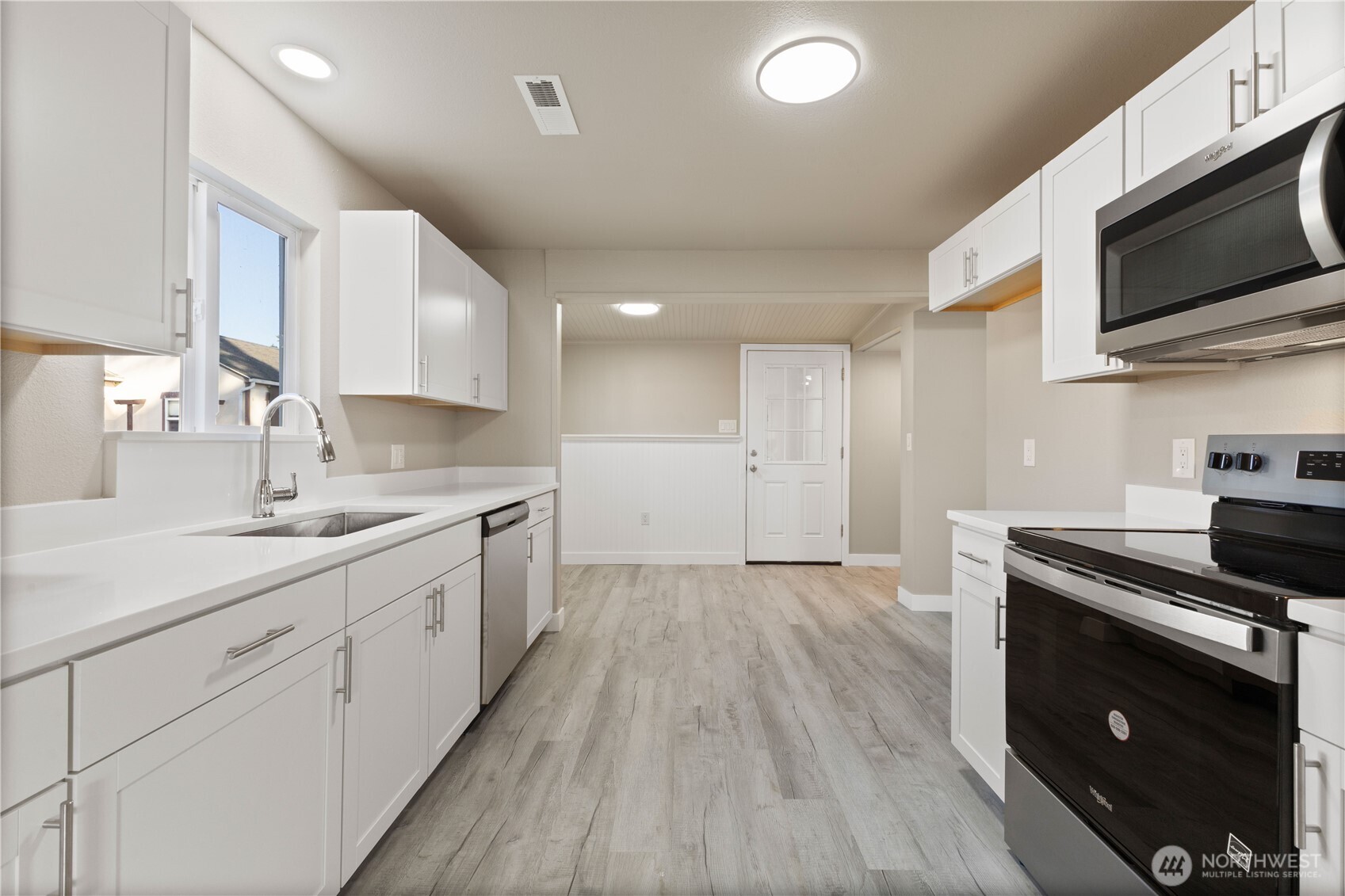 639 Elizabeth Street Sumner, WA 98390 - Photo 7 of 26 a kitchen with a sink a microwave and cabinets