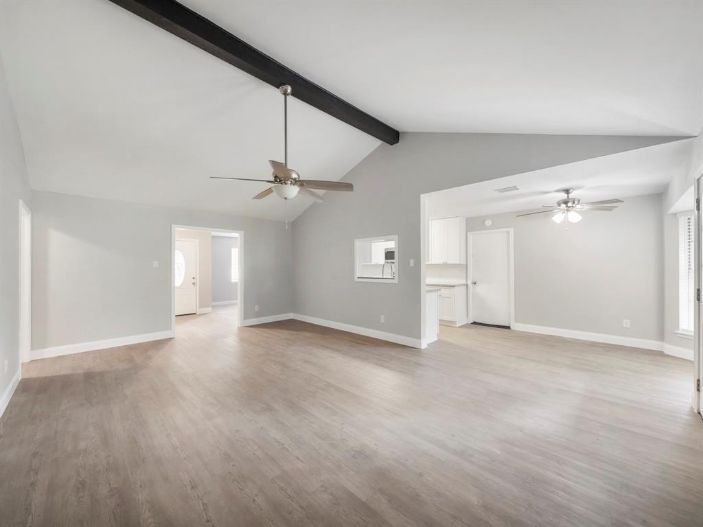 an empty room with ceiling fan and closet area